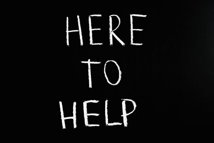 The words &#039;here to help&#039; written in white against a black background.