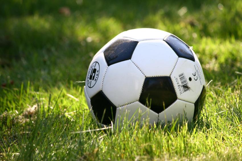 A photograph of a football lying on the grass.