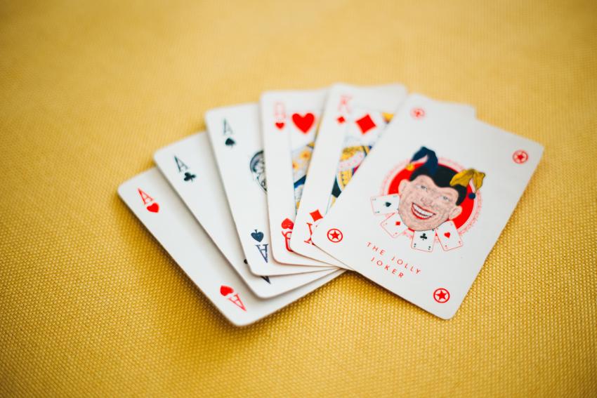 A set of playing cards spread out on a yellow board. 